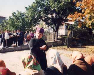 Православный служитель убеждает старушек в истинности православной веры. Баптистский хор (на заднем плане) в это время исполняет ВЕРУЮ